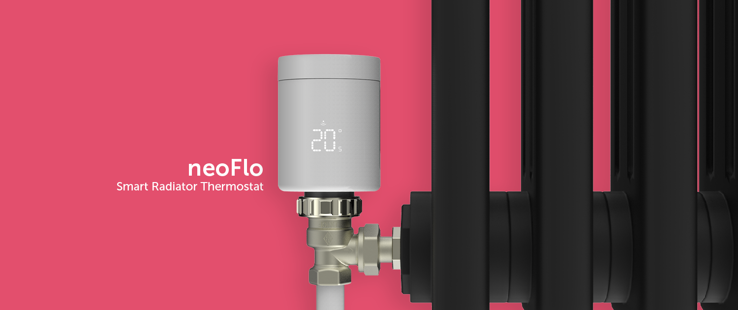 The neoFlo smart radiator head affixed to a black radiator TRV on a red wall.